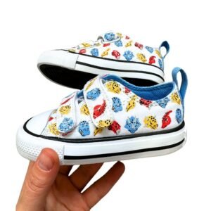 Calzado Converse All Star blancas para bebé con estampado de dinosaurios y cierre de velcro.