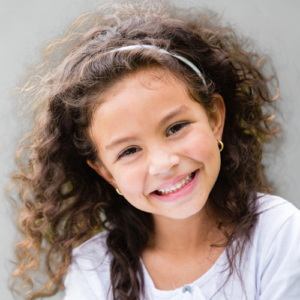 Niña riendo con ropa moda europea en Paraguay